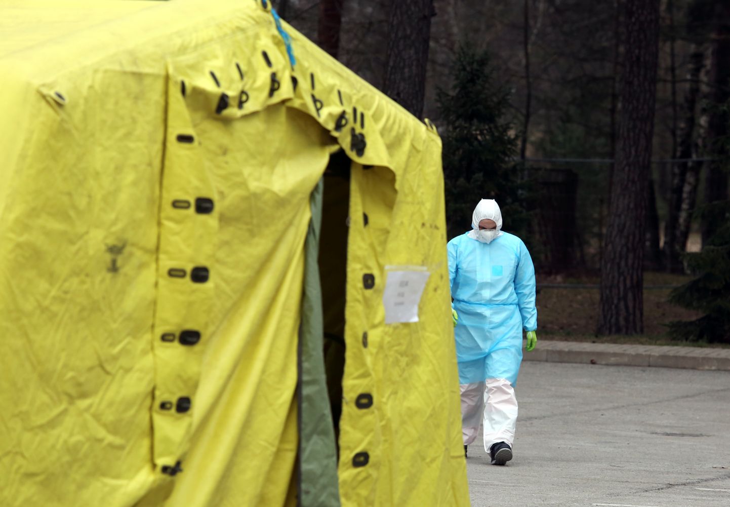 Mediķis aizsargtērpā pie telts Latvijas Infektoloģijas centrā, kurā iespēja nodot analīzes uz Covid-19.