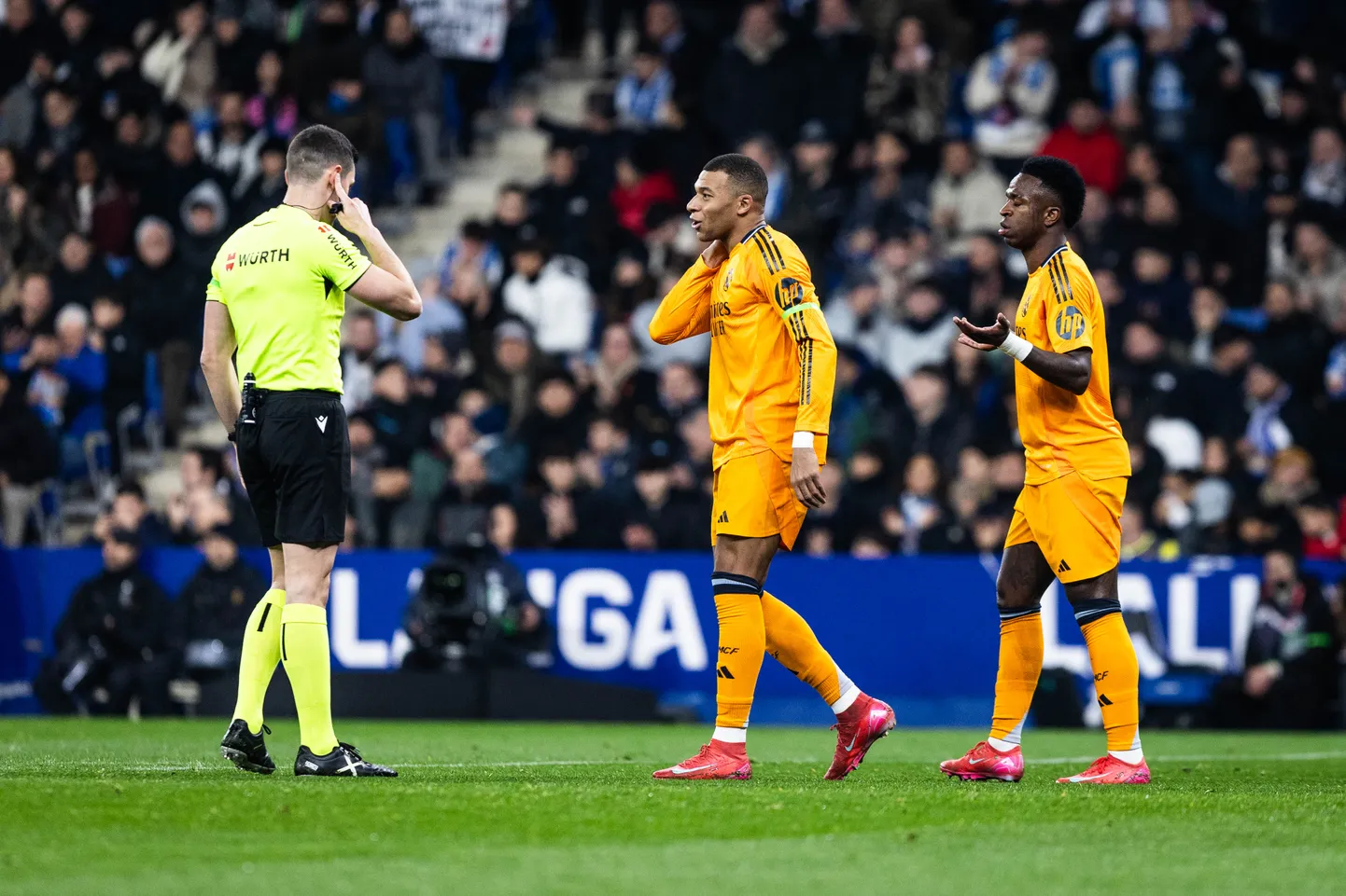 Madridi Reali staarid Kylian Mbappé ja Vinicius (oranžis) vaidlemas kohtunikuga.