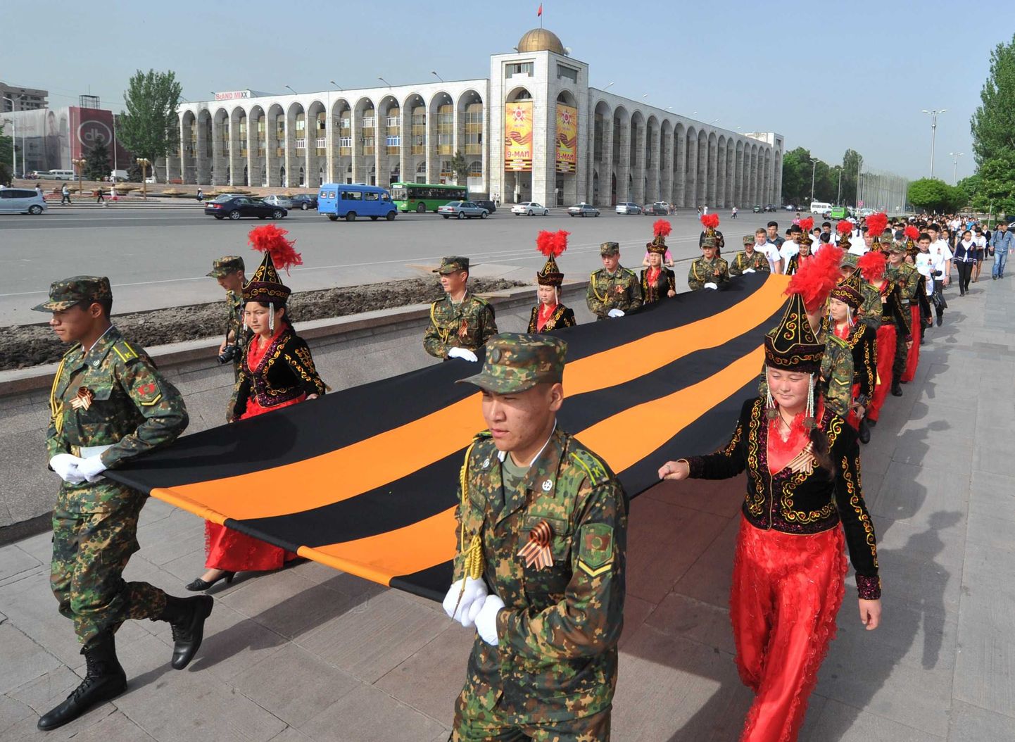 Rahvariides kirgiisitarid ja sõjaväelased 7. mail suure Georgi lindiga paraadil.