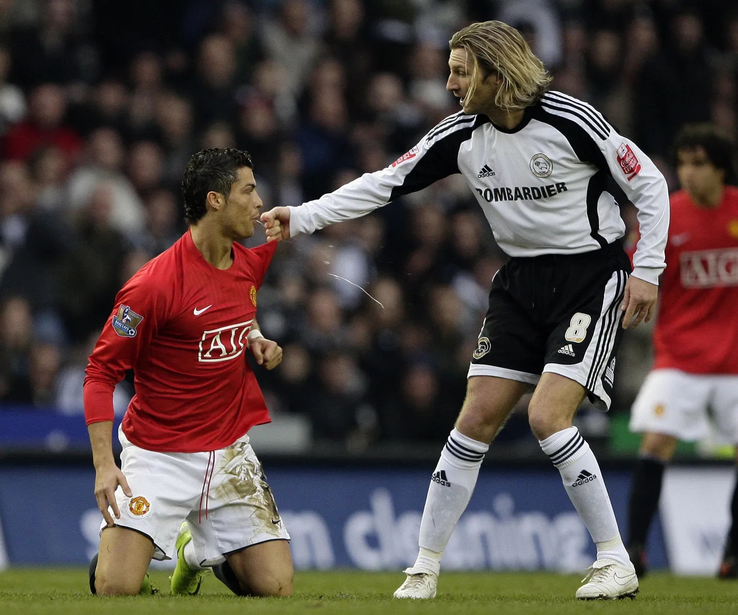 Cristiano Ronaldo (põlvili) sülitamas Derby County Robbie Savage'i suunas.