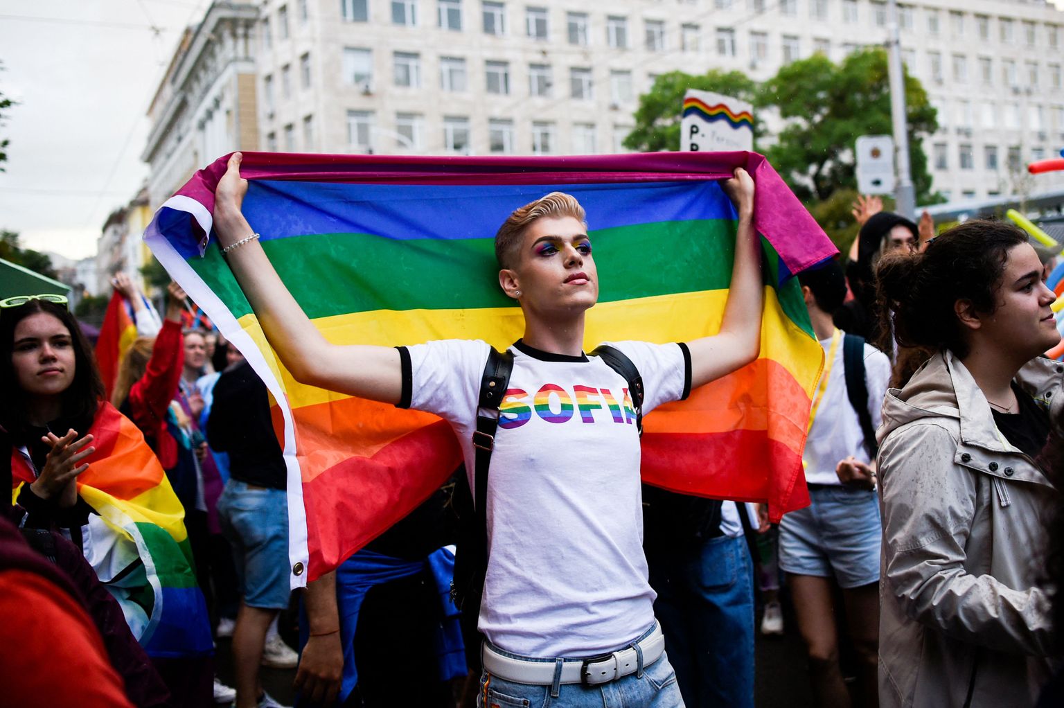 Aktīvists tur varavīksnes karogu ikgadējās geju praida parādes laikā Sofijas centrā 2021. gada 12. jūnijā.
