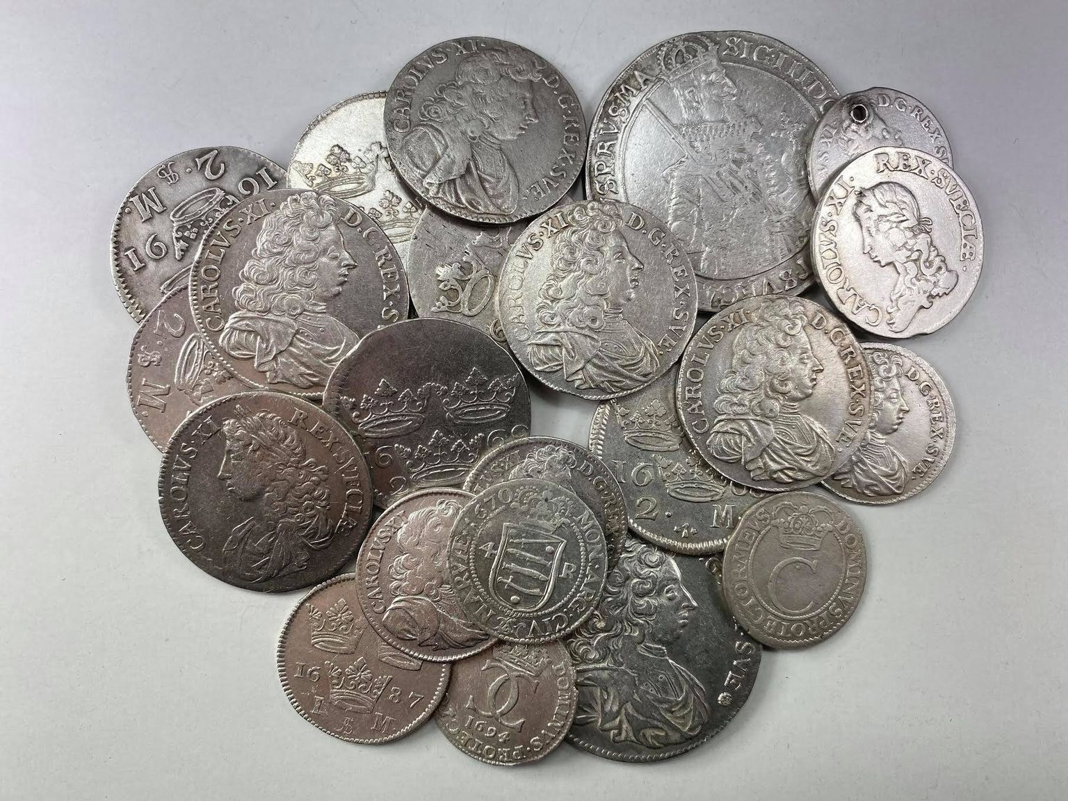 Mündid Vinni aardeleiust. All keskel on Narvas aastal 1670 vermitud neljaöörise hõbemündi revers.
