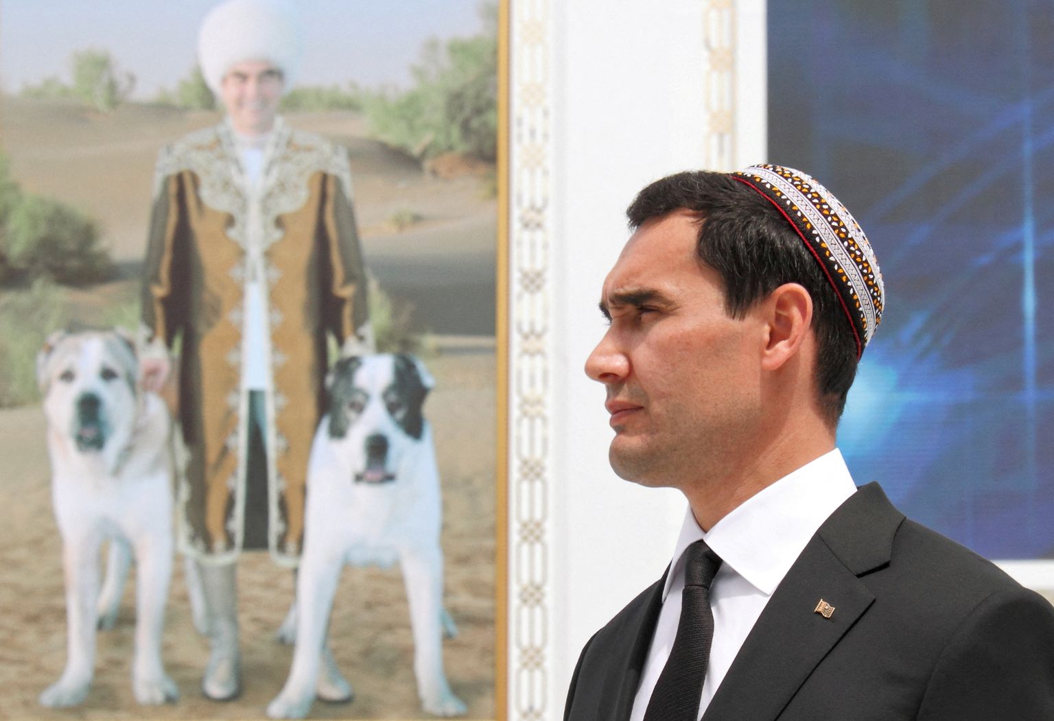 Türkmenistani asepeaminister ja tõenäoline tulevane president Serdar Berdõmuhhamedov. Taustal pilt tema isast, president Gurbangulõ Berdõmuhhamedovist koertega.