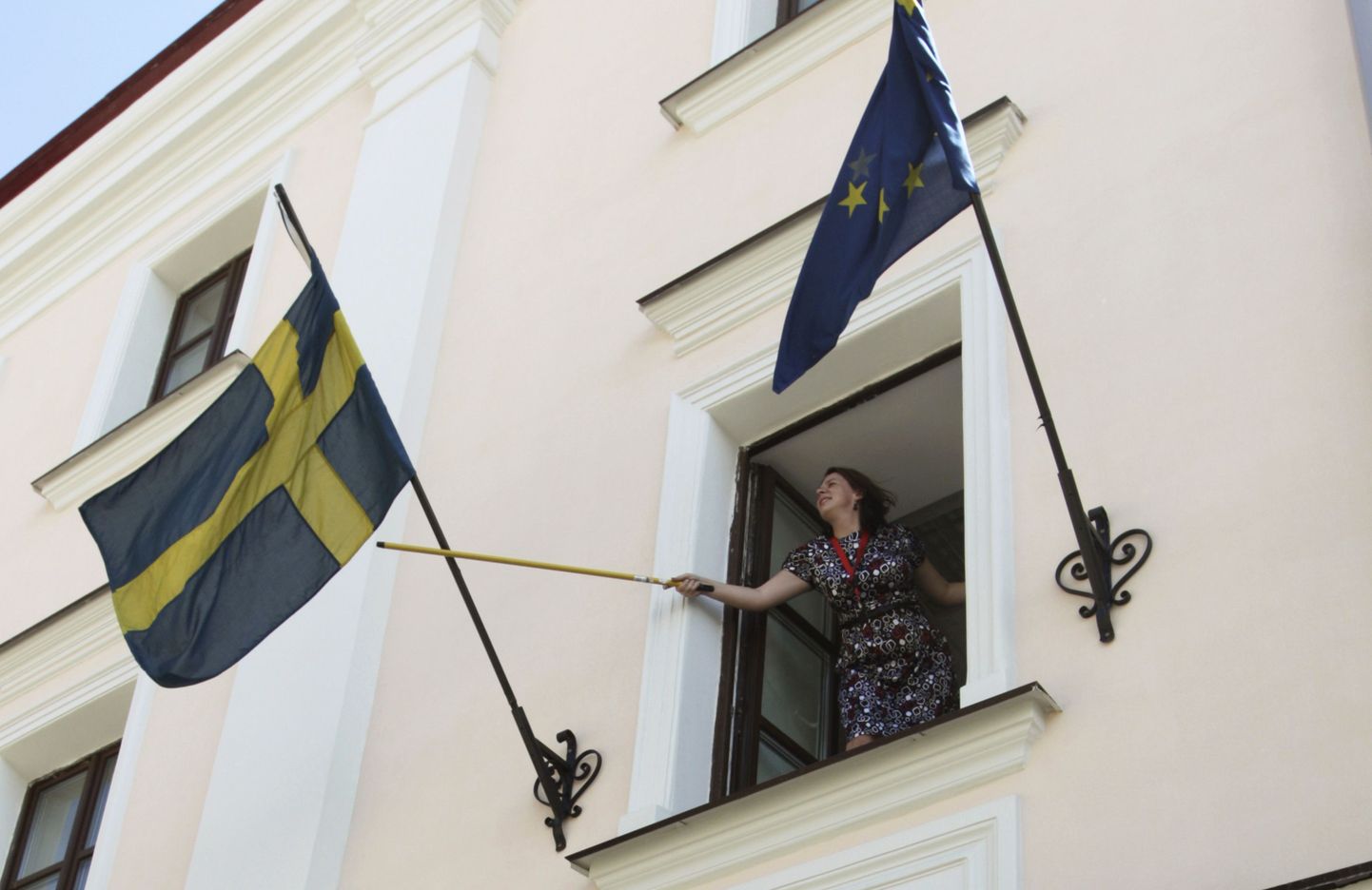 Töötaja eile Minskis asuvas Rootsi saatkonnas riigilippu kohendamas.