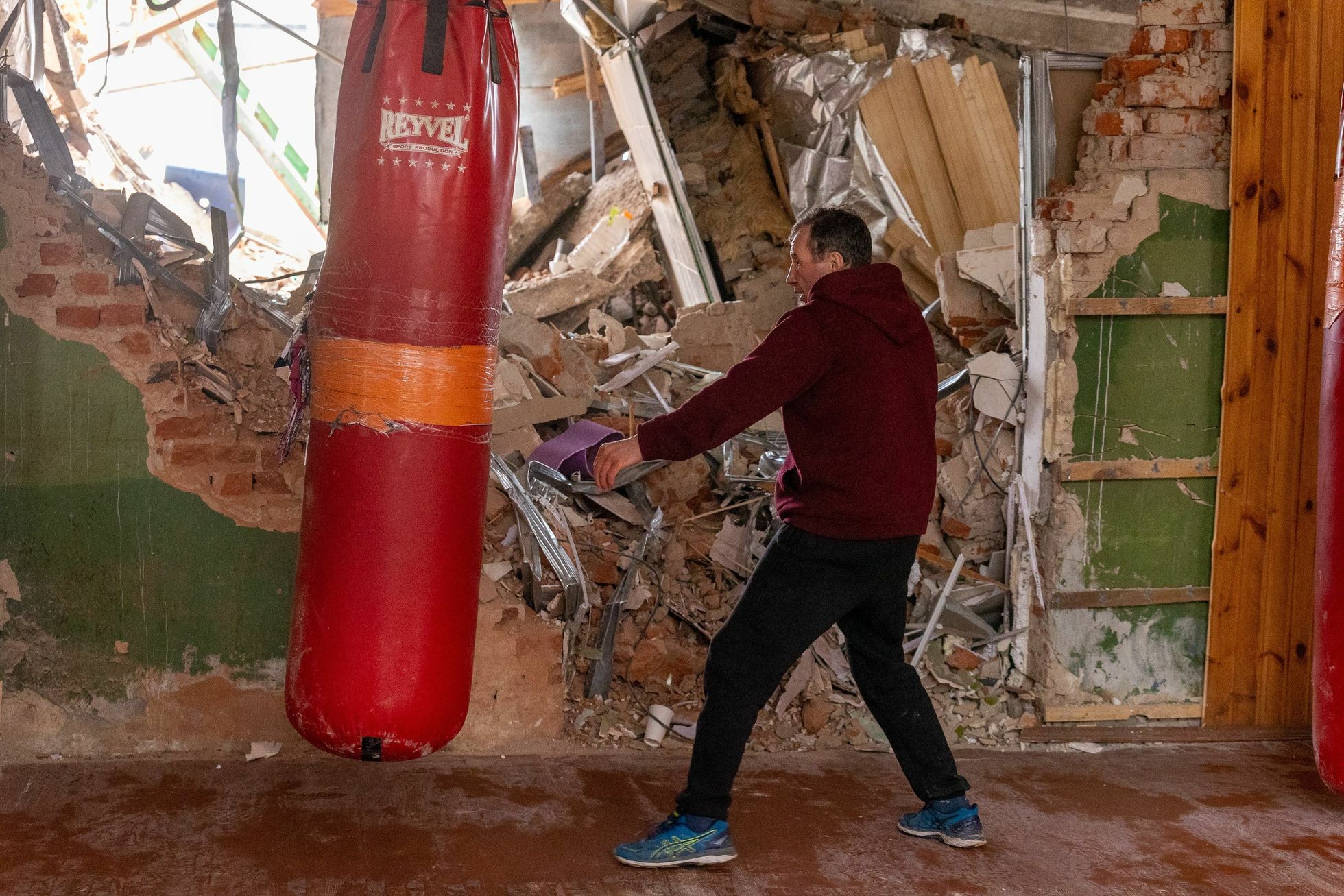 Tšernihivi staadioni poksisaali treener Mihhail Kostjušok teeb trenni purustatud seina ees.