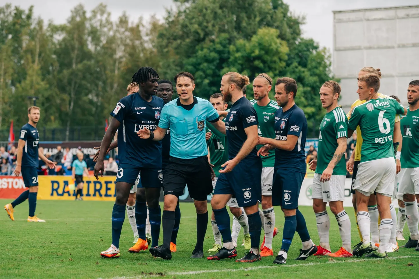 Paide ja Levadia mängijad ümbritsevad kohtunik Grigori Ošomkovit. Henri Anier (kohtunikust paremal) uurib, miks tema löödud värav ei lugenud.  FOTO: Liisi Troska / jalgpall.ee