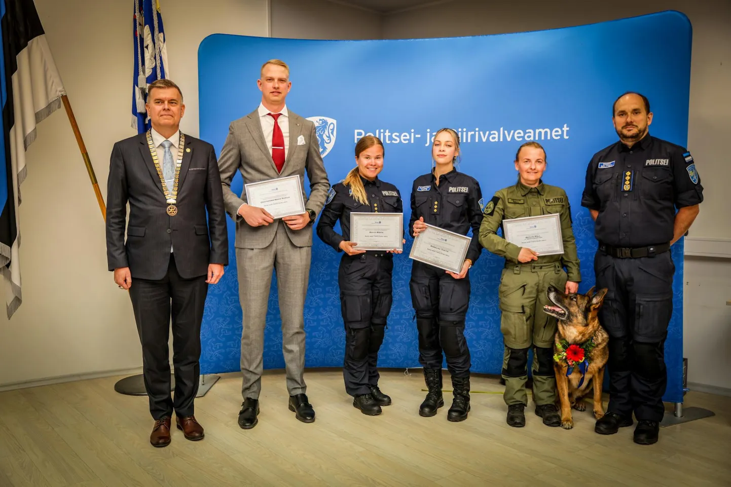 Tallinna Rotary klubi esindaja Ain Käpp (vasakult), keskkriminaalpolitsei isikukaitse büroo ihukaitsja Cristopher-Kevin Kunila, Edith Rästa, Põhja prefektuuri uurija Karolina Tupits, koerajuht Ketlyn Päll ja teenistuskoer Isak ning PPA peadirektor Egert Belitšev