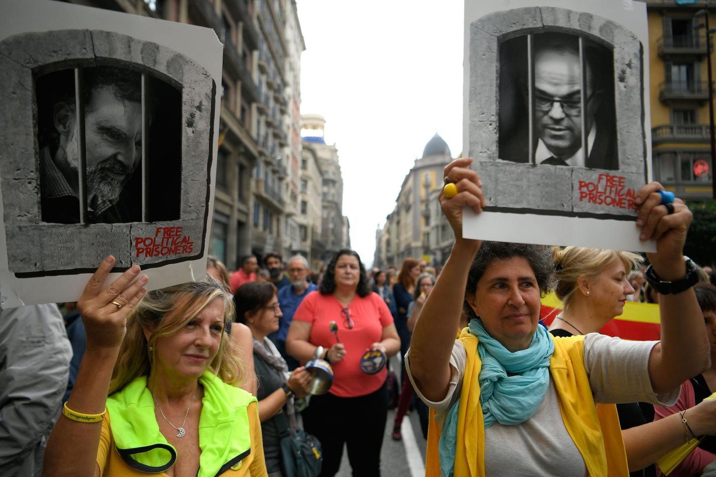 Kataloonia iseseisvusliikumise vangi mõistetud liidrite Jordi Cuixarti ja Jordi Turulli pilte kandvad meeleavaldajad eile Barcelona tänaval. 