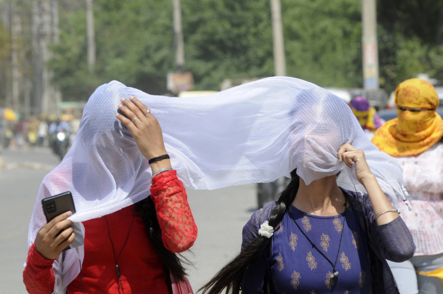 Kuuma eest varju otsivad naised Delhis.