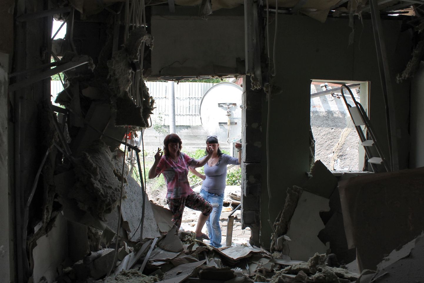 Naised inspekteerivad Donetski mürsurünnakus hävinud maja.