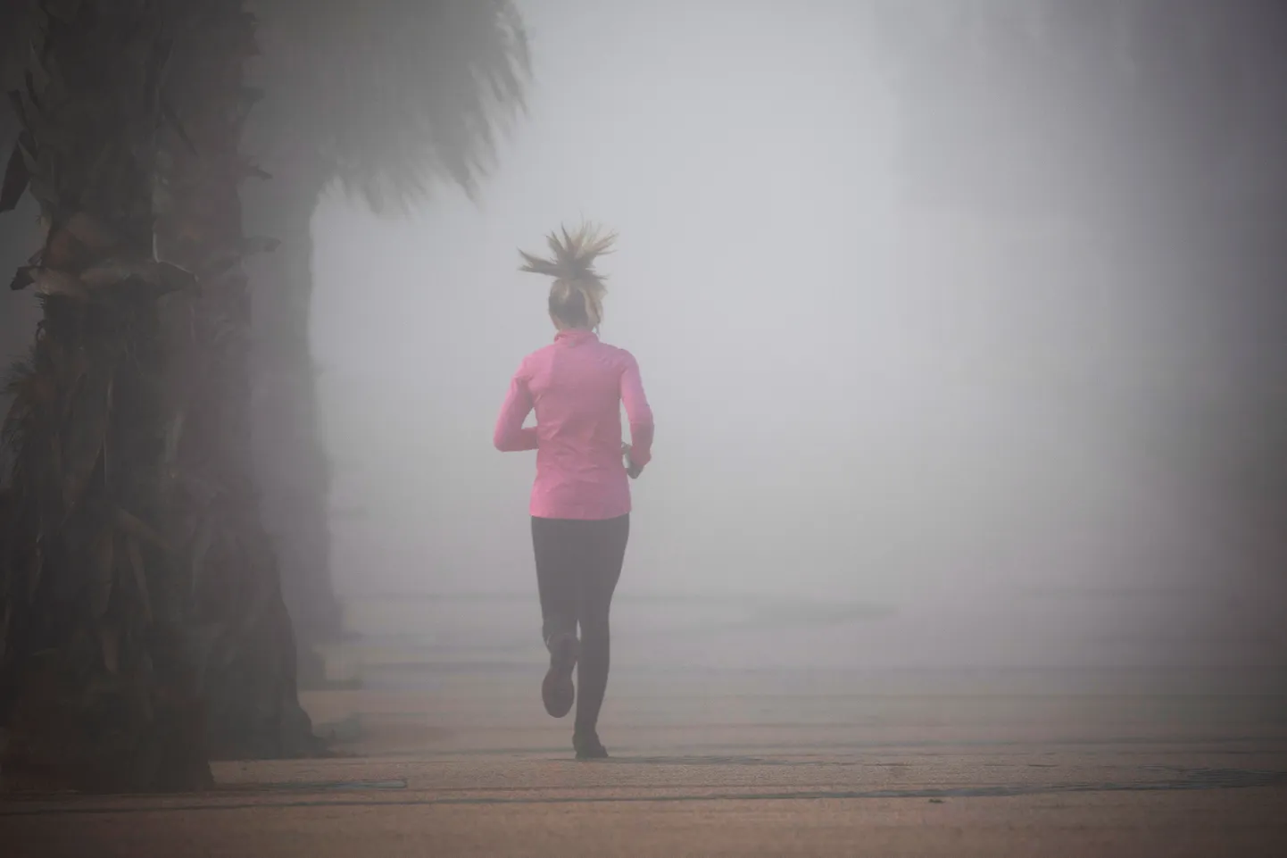 A woman jogs through morning fog at the promenade in Ashkelon, southern Israel January 7, 2021. REUTERS/Amir Cohen