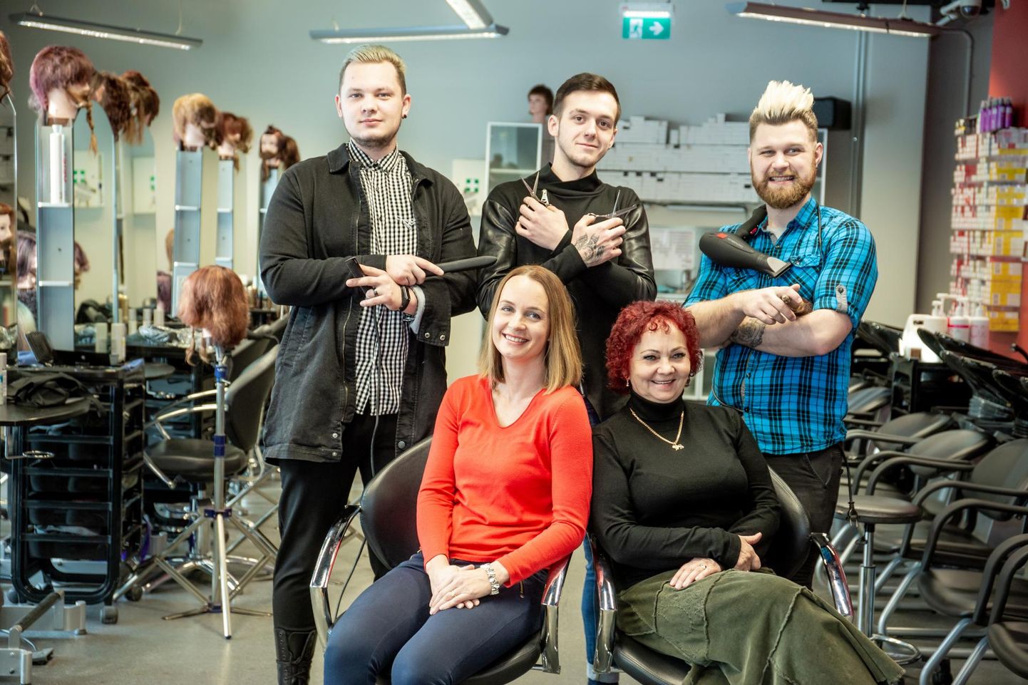 Pärnumaa kutsehariduskeskuse juuksuri eriala lõpetavad (vasakult) Martin Jürgenson, Riiko Kojoni ja Reymo Rebane, kelle ees kooli juuksurisalongis istuvad metsakasvatajad Terje Prisk ja Inga Kaldvee.