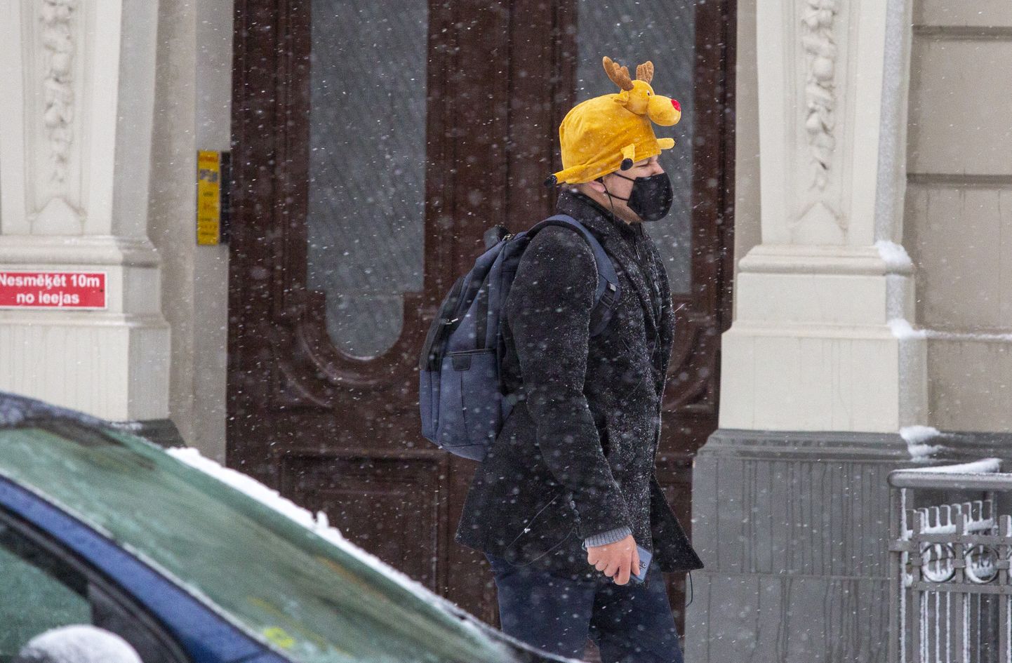 Vīrietis uz ielas sniegputeņa laikā.