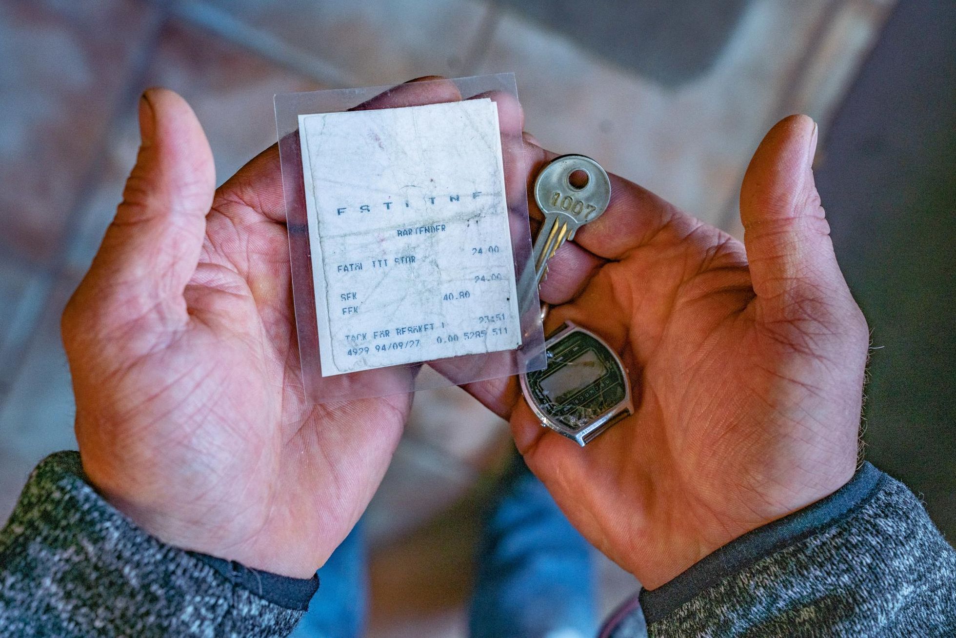 Вельо показывает вещи, сохранившиеся в кармане его джинсов при крушении "Эстонии": чек за пиво, ключ от каюты и наручные часы. 