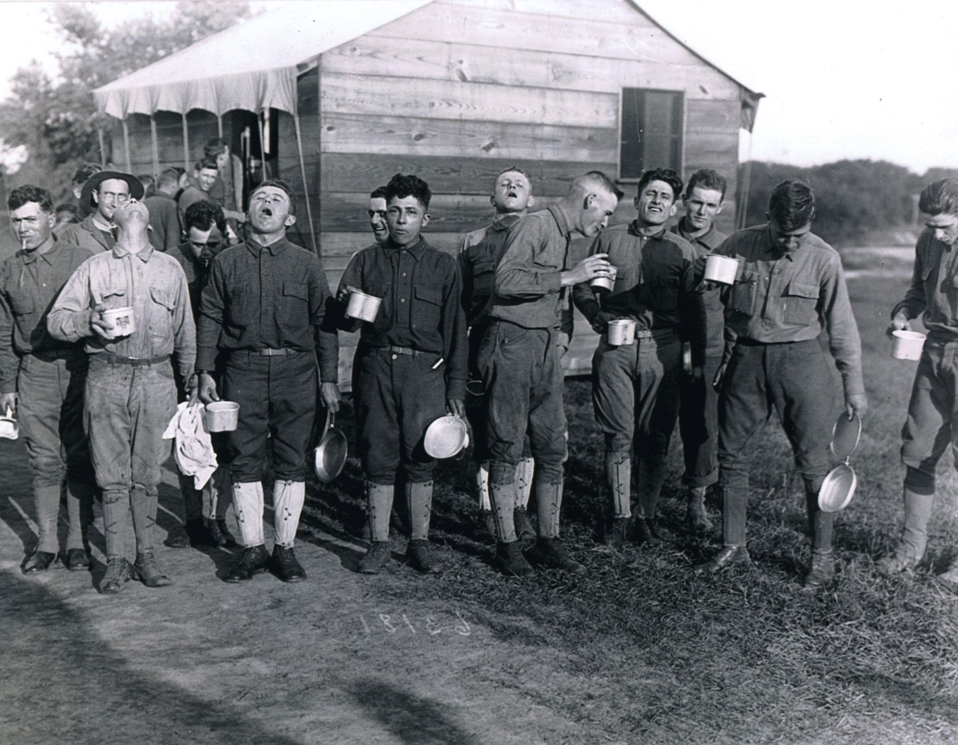 Солдаты на военной базе «Кэмп Дикси» в Нью-Джерси (США) в сентябре 1918 года. После рабочего дня они полоскают рот соленой водой, полагая, что это поможет избежать заражения.