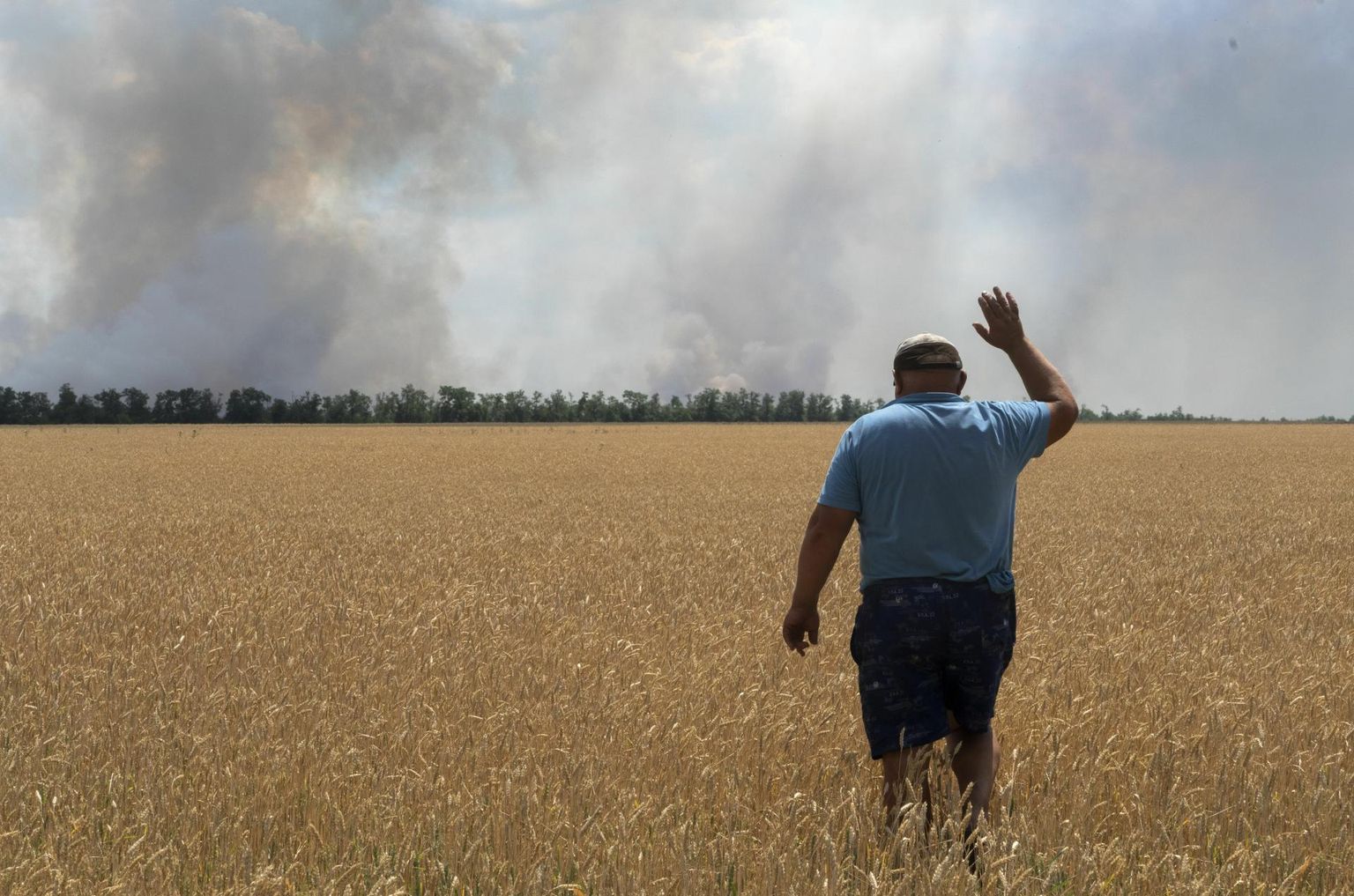 Ukraina põllumees Dnipropetrovski oblastis vaatab, kuidas põllult suitsu kerkib.