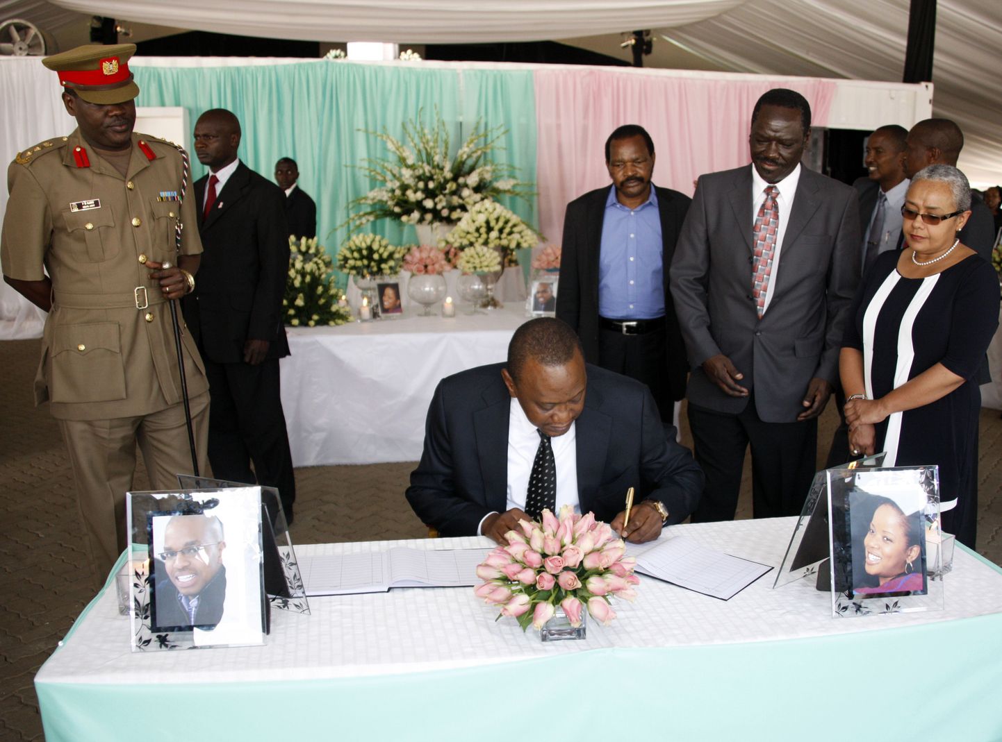 Keenia president Uhuru Kenyatta (keskel), keda saadab tema abikaasa Margaret Kenyatta (paremal), kirjutab Nairobi katedraali juurde paigutatud kaastundeavalduste raamatusse.
