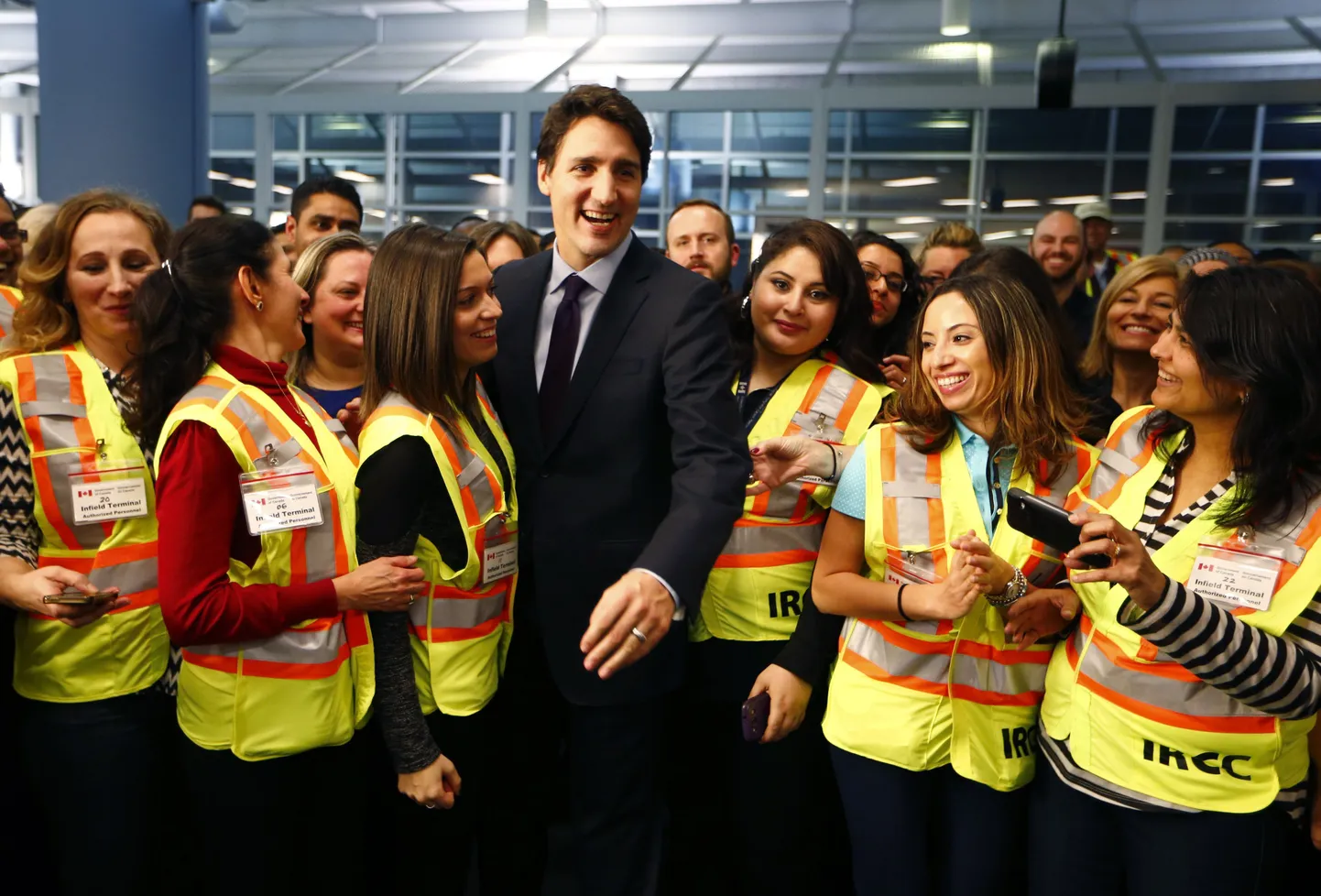 Kanada peaminister Justin Trudeau koos lennujaamapersonaliga põgenikke ootamas.
