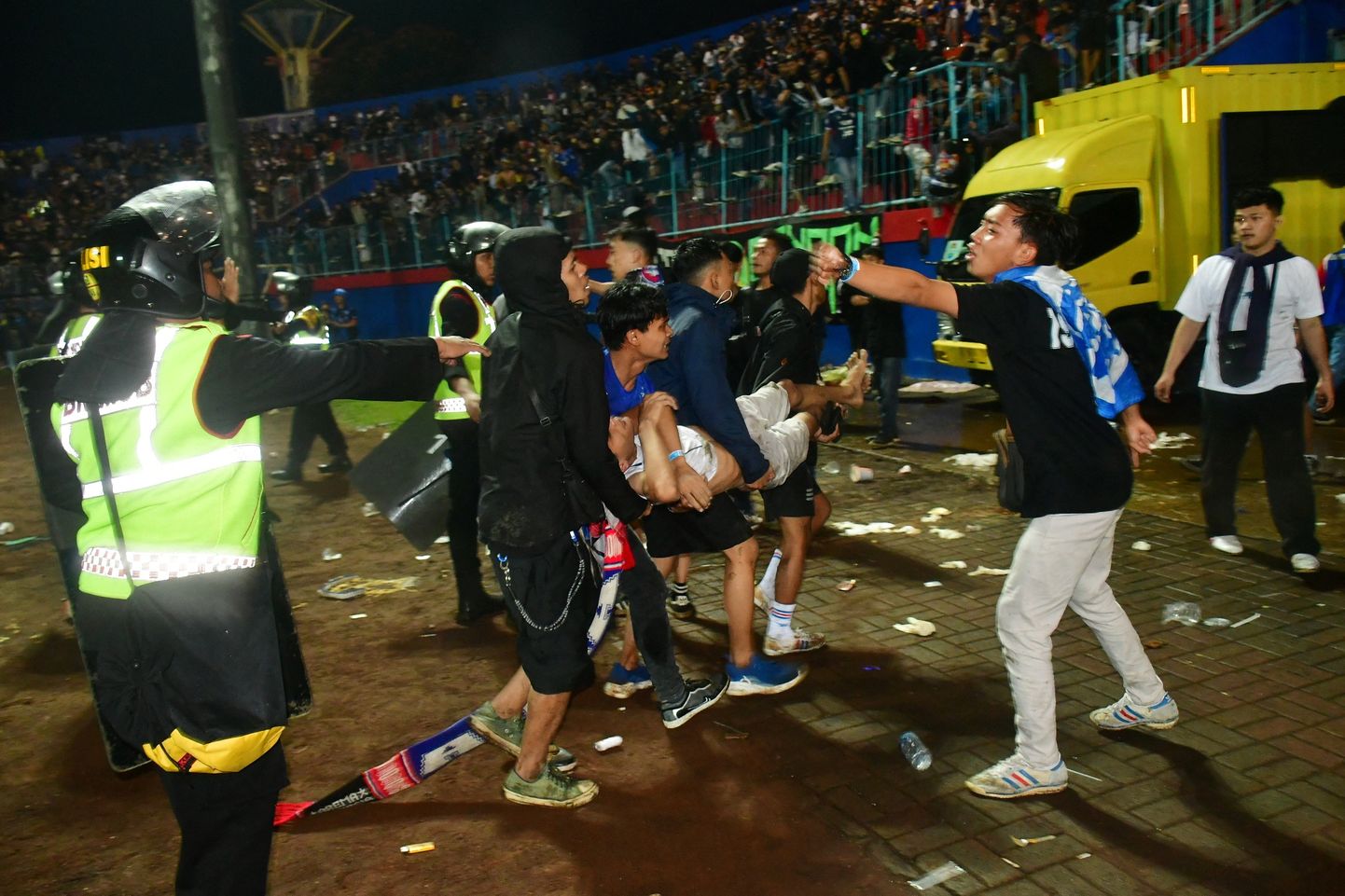 Kaader Indoneesia traagilisest jalgpallimängust, kus fännid politsei eest põgenevad.