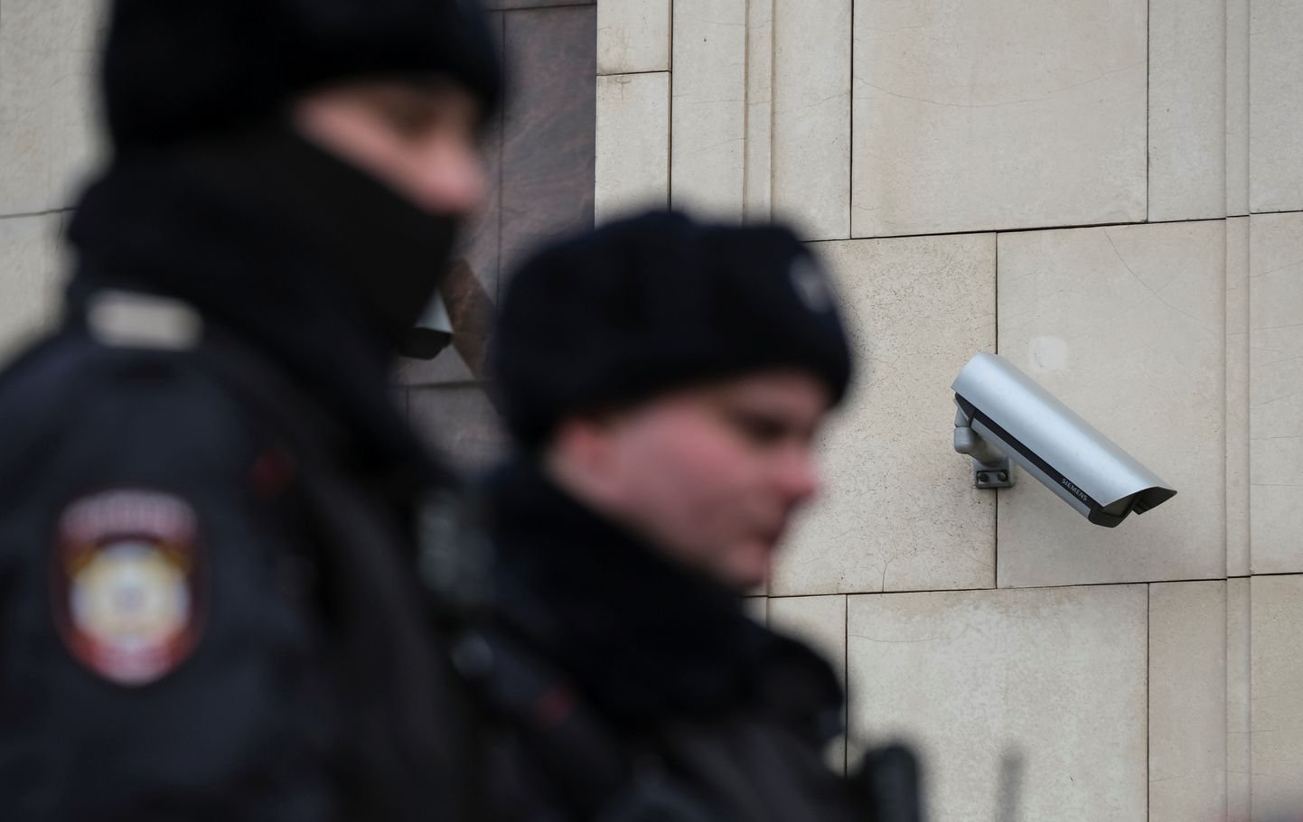 Vene politseiametnikud Moskva kesklinnas maja nurgal, kuhu on paigaldatud turvakaamera.