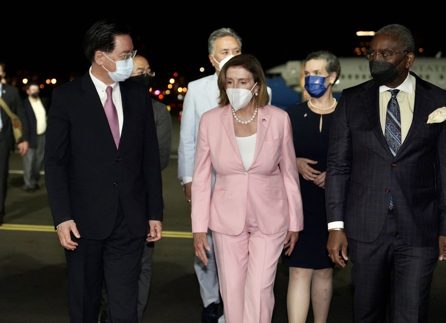 USA esindajatekoja spiiker Nancy Pelosi (roosas pükskostüümis, keskel) 2. augustil 2022 Taiwani Taipei Songshani lennujaamas koos kaaskonna ja Taiwani välisministri  Joseph Wuga (vasakul)