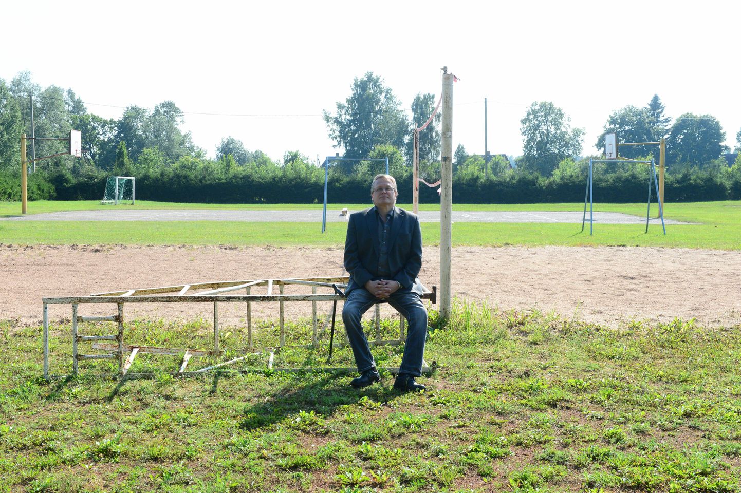 Vallavolikogu esimees Urmas Paju istub rannavõrkpalli platsi ääres, kuhu järgmisel aastal rajatakse staadion.
