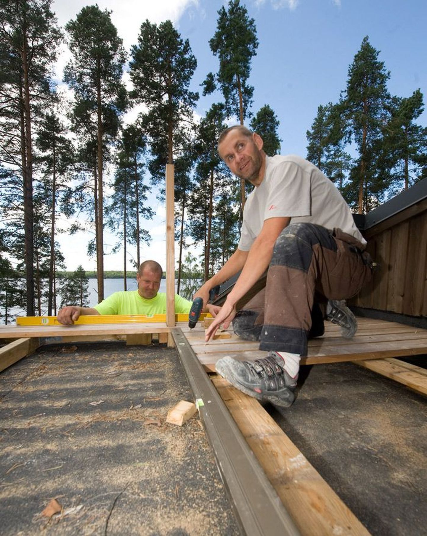 Andres Võlli (vasakul) ja Mihkel Vaap ehitavad päeval Saimaa järve kaldale maja, aga õhtul istuvad terrassil ja hoiavad silma peal oma pardiperel.