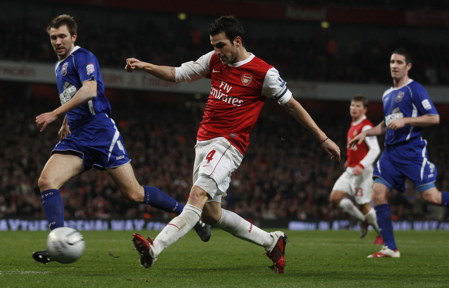 Arsenal's Cesc Fabregas scores past Ipswich Town's Gareth McAuley (L) during their English League Cup semi-final second leg soccer match at Emirates Stadium in London January 25, 2011. REUTERS/Eddie Keogh       (BRITAIN - Tags: SPORT SOCCER)