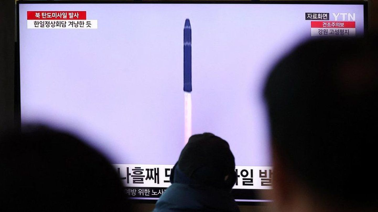 Жители Сеула наблюдают за пуском северокорейской ракеты по телевидению.