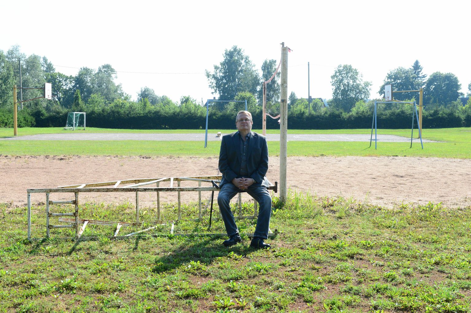 Vallavolikogu esimees Urmas Paju istub rannavõrkpalli platsi ääres, kuhu järgmisel aastal rajatakse staadion.