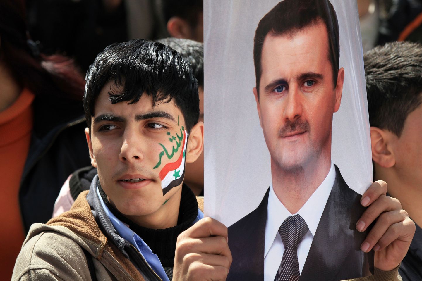 Süüria demonstrant president Bashar al-Assadi portreega.