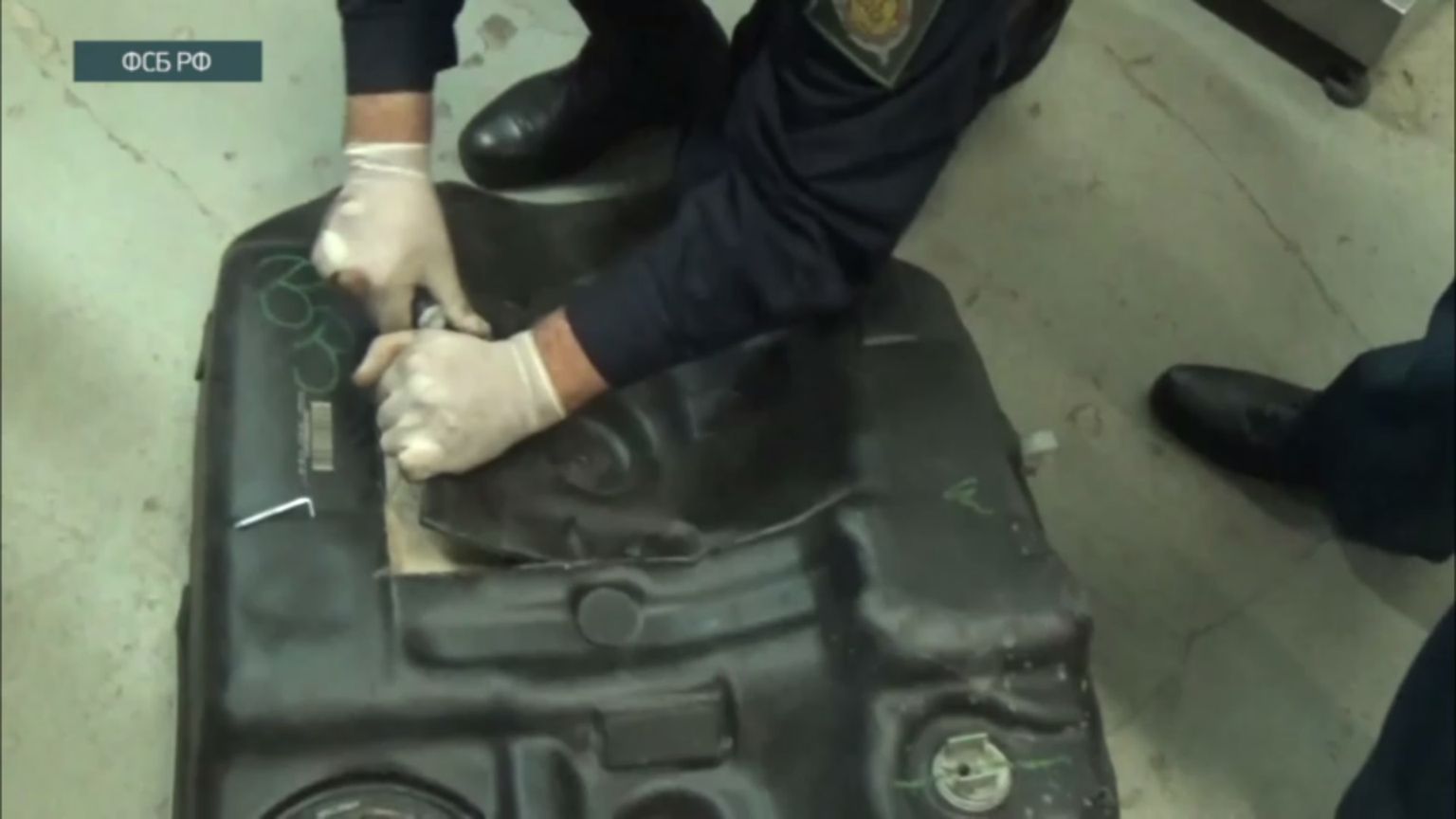 Кадр из видео ФСБ, на котором проверяется бензобак автомобиля, на котором граждане Украины якобы собирались ввезти в Россию из Латвии 57 кг наркотиков