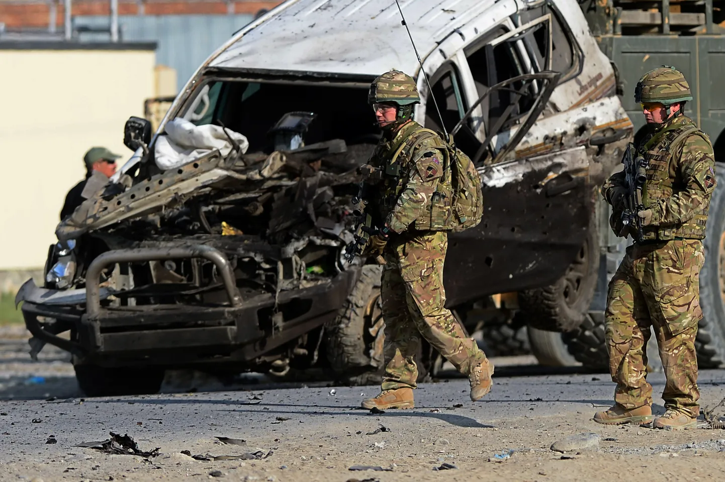 USA sõdurid Kabulis suitsiidirünnakus kahjustada saanud auto kõrval.