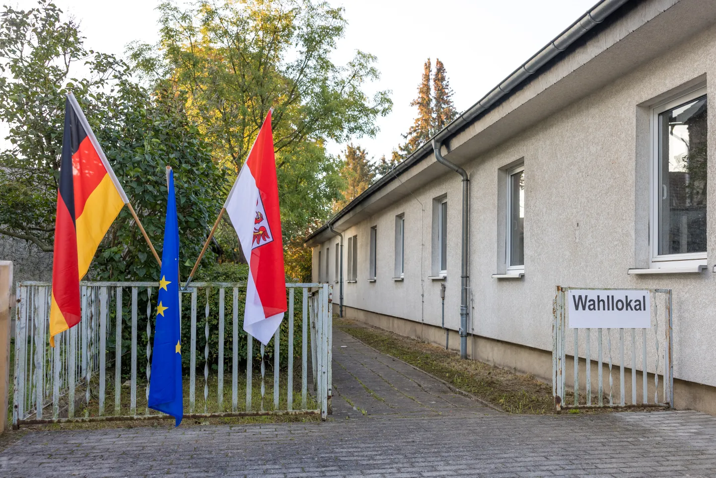 Valimisjaoskond Potsdamis, selle ees Brandenburgi liidumaa, Saksamaa ja Euroopa Liidu lipp.