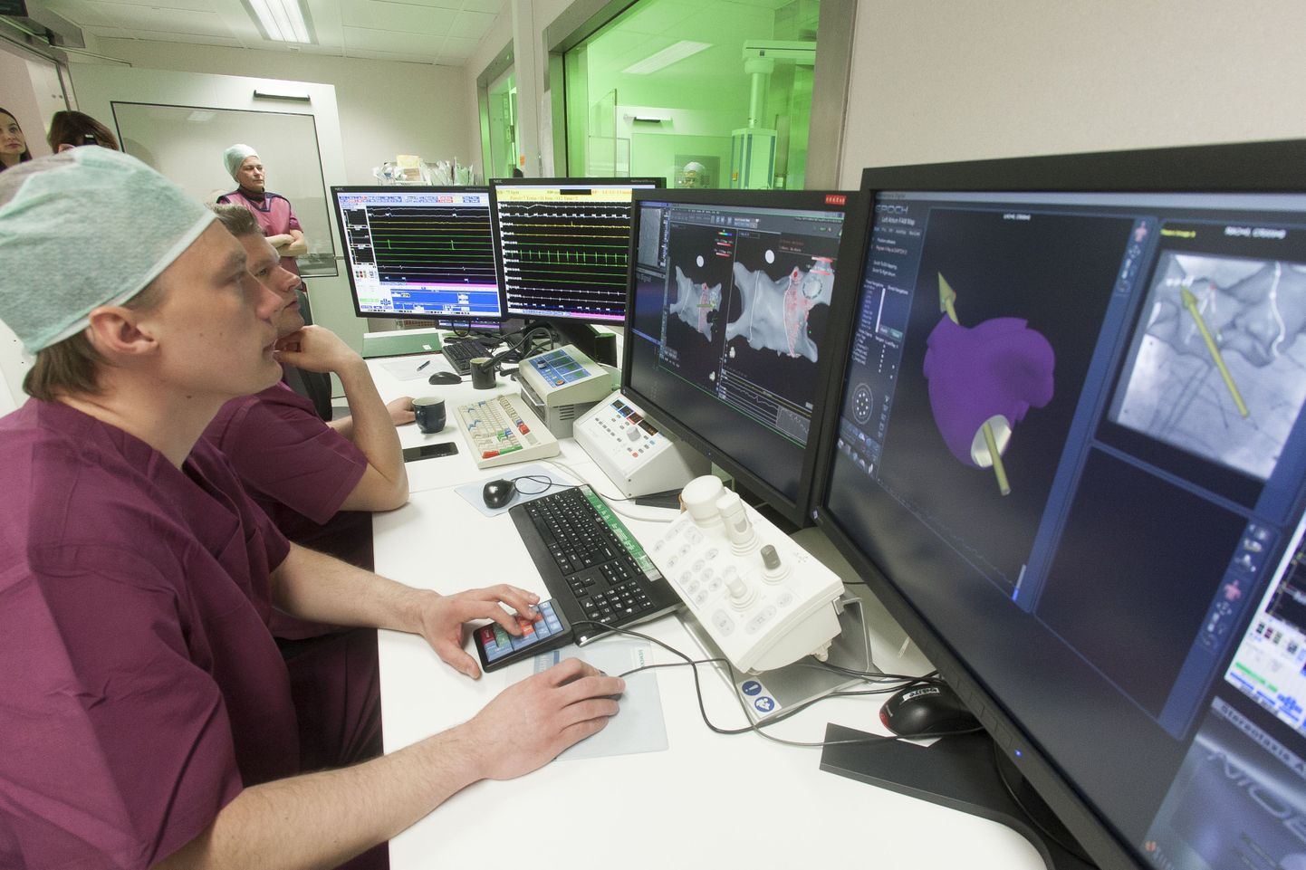 Põhja-Eesti regionaalhaigla kardioloogiakeskuse invasiivkardioloogia osakonna arst Priit Kampus juhib kateeterablatsiooni protseduuri arvuti tagant. Patsient asub kõrvalruumis klaasseina taga.