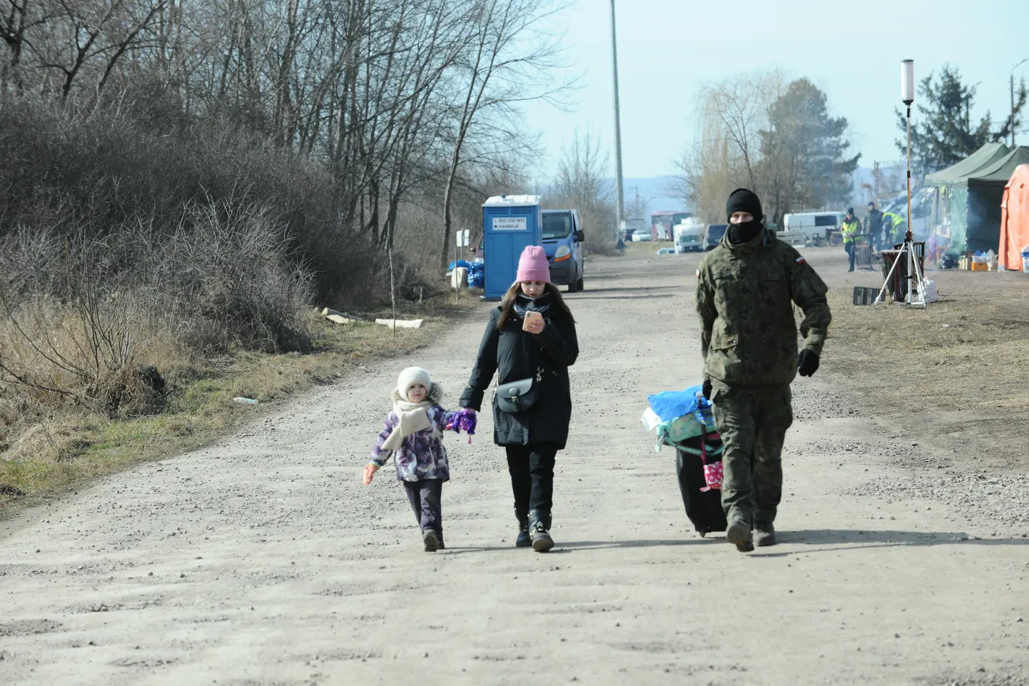 Poola sõdur aitab emal ja lapsel pagasit kanda
