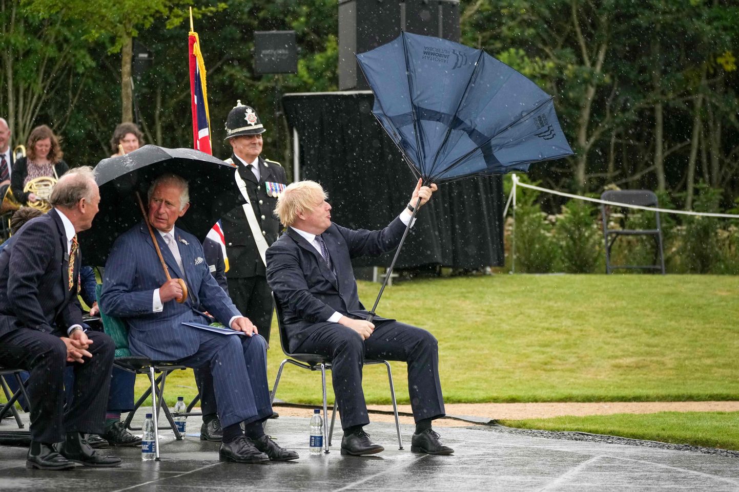 Boris Johnson vihmavarjuga maadlemas.