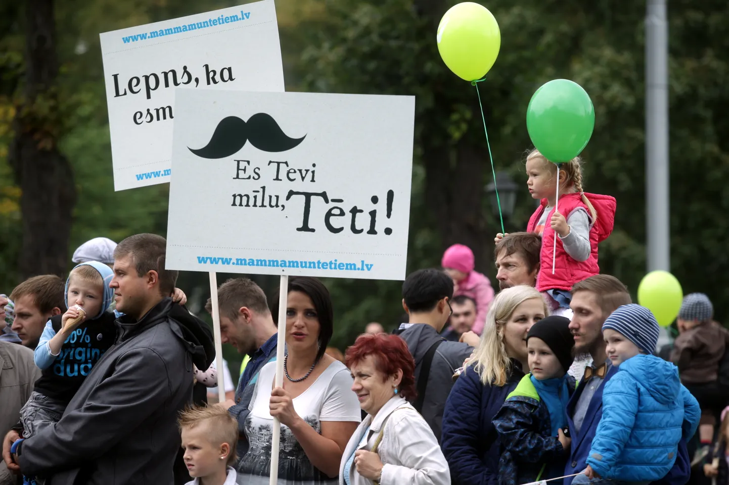Cilvēki pulcējas pie Brīvības pieminekļa, lai dotos Tēva dienas gājienā uz Esplanādi.