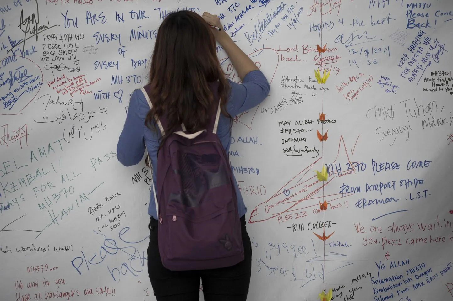 Kuala Lumpuri lennujaamas saavad inimesed kirjutada suurele plakatile oma sõnumeid kaotsiläinud lennuki reisijaile.