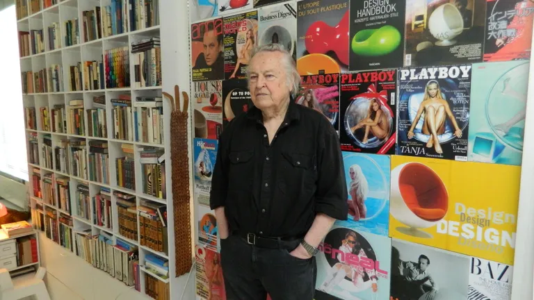 Eero Aarnio poseerib oma reklaamseina taustal, foto: