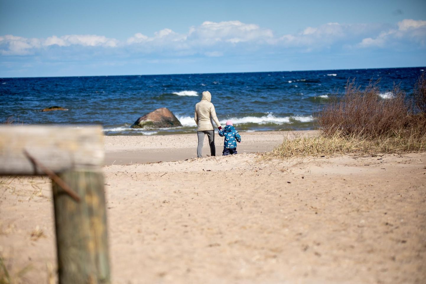 Гуляющий с ребенок человек сегодня до обеда на пляже Карепа.