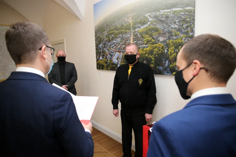 Tartu linnapea Urmas Klaas tunnustab Skarabeus turvafirmas töötavat Aivar Volast uppuja päästmise eest kellaga. Pildil koos Skarabeusi tegevjuhi Rode Pärn-Mägiga (vasakul).