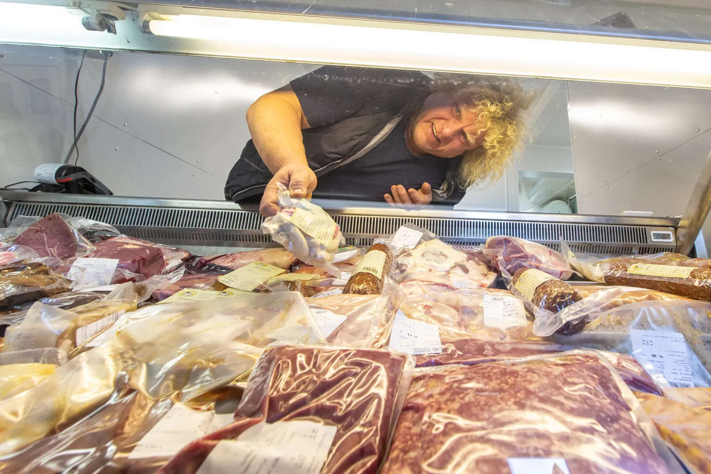 В открывшемся в позапрошлую пятницу магазине можно запастись продуктами из баранины, но на прилавке представлены также свинина, говядина и птица. Яак Арм показывает одну из новинок - радующие детей разноцветные куриные сосиски.
