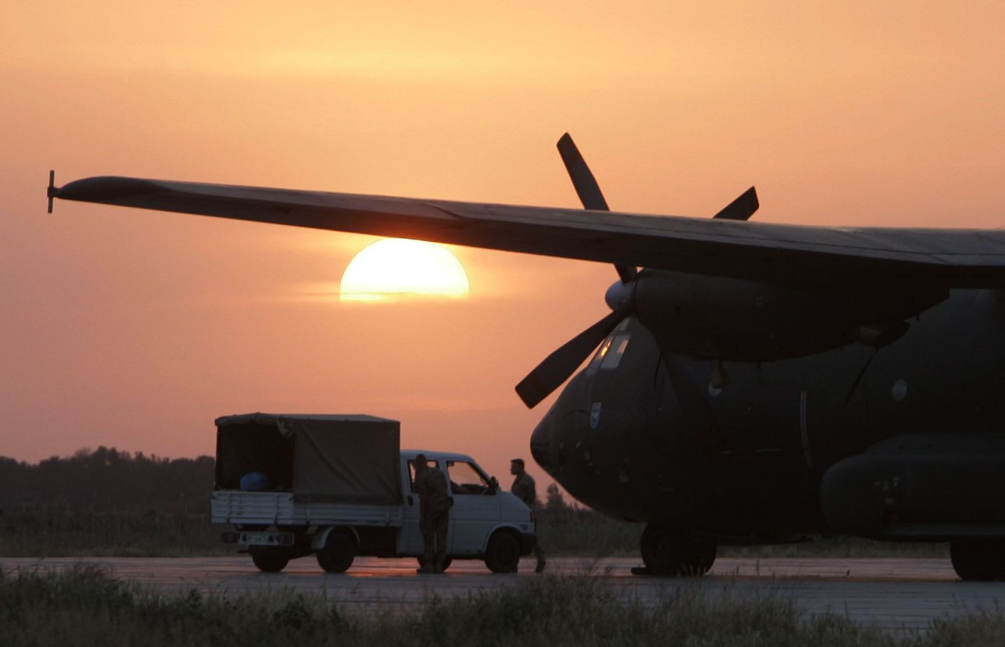 Päikeseloojang Termezi lennuväljal Usbekistanis. Paremal seisab Saksa õhujõudude C-160 transpordilennuk.