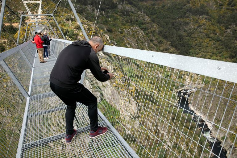 Мужчина снимает открывающийся с моста вид. 