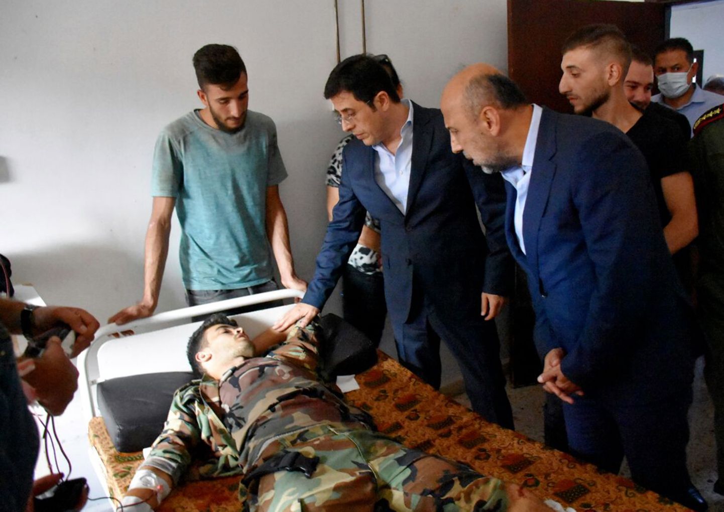 Süüria tervishoiuminister Hassan al-Ghabash külastamas droonirünnakus haavatuid Homsi haiglas.
