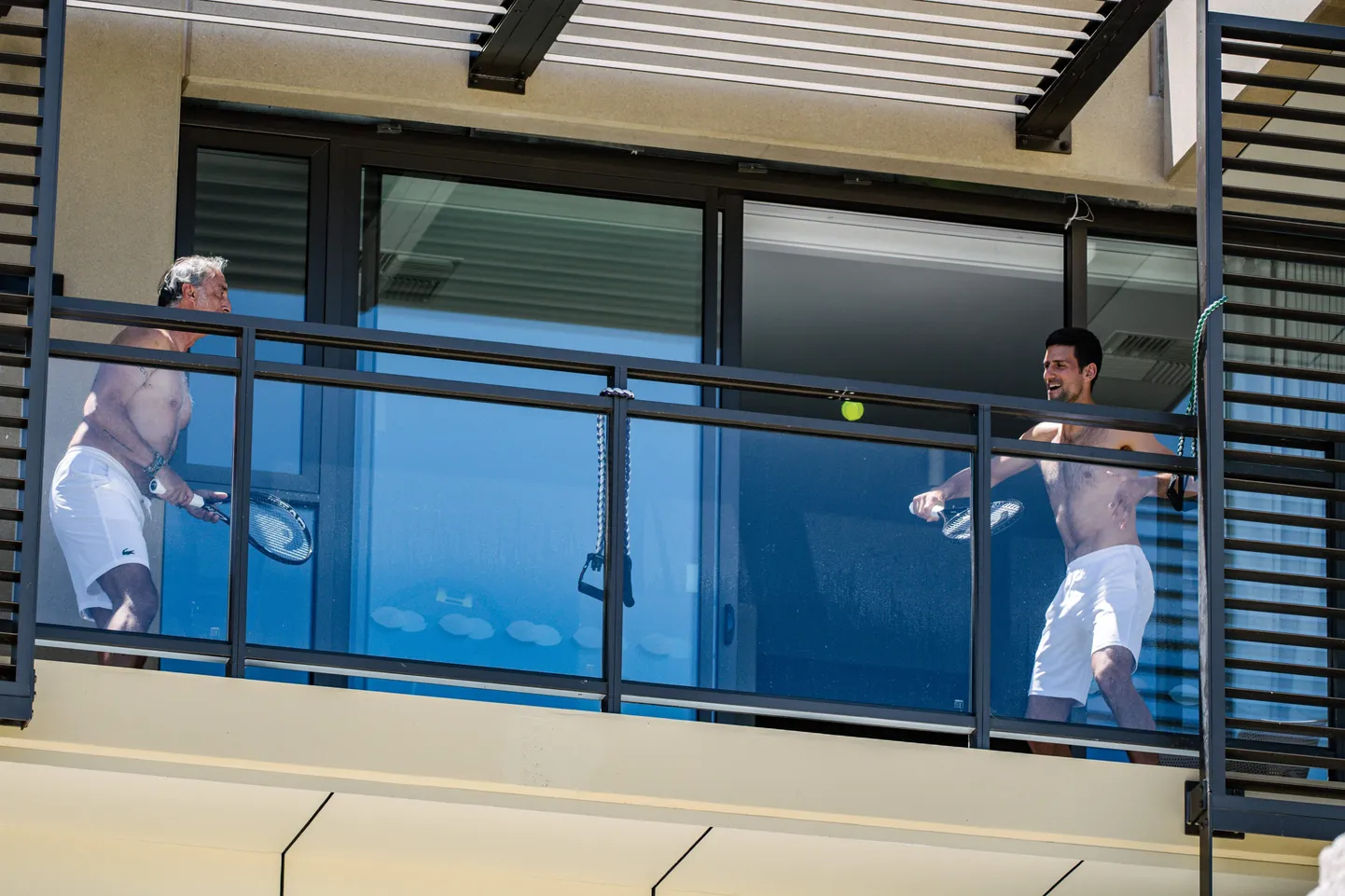 Pasaules ranga līderis Novāks Džokovičs spēlē tenisu uz balkona.
