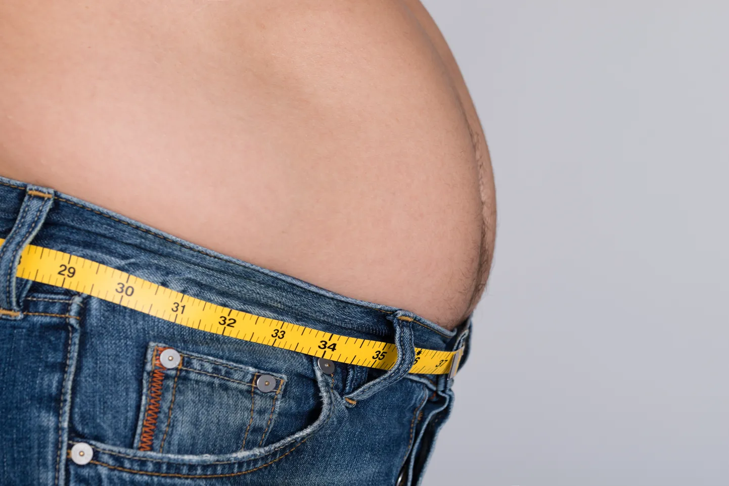 Midsection Of Fat Man With Measure Tape Around Waist