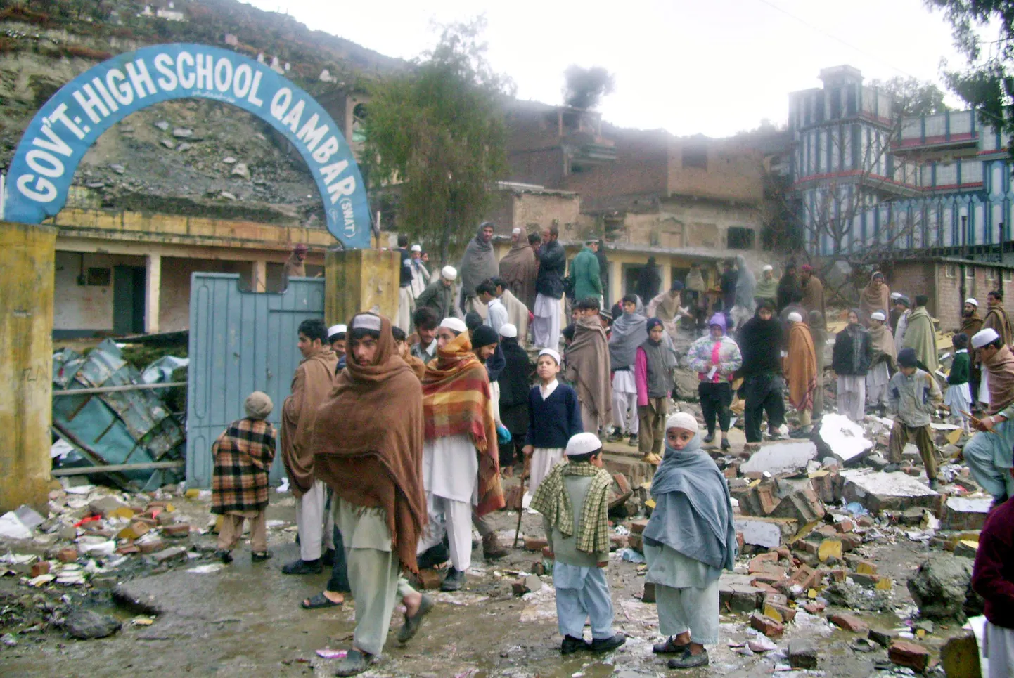 Pakistani õpilased kogunemas Swati orus purustatud koolimaja rusudele.