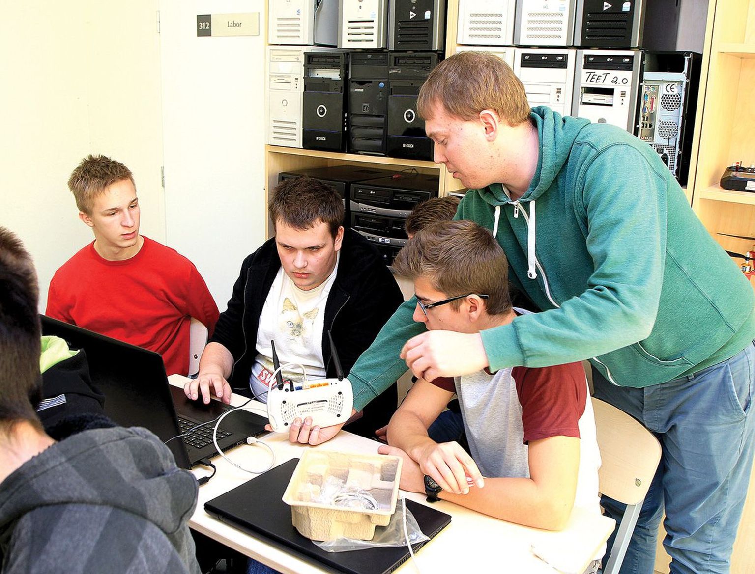 Küberkaitseõpetaja Ats Teppan (seisab) näitab (vasakult) Hans Annistele, Raito 
Kösterile ja Sander Saarele, kuidas 
seadistada ruuterit nii, et see tõrgeteta tööle hakkaks.